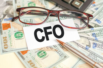On the table are bills, a bundle of dollars and a sign on which it is written - CFO. Business and Finance concept.