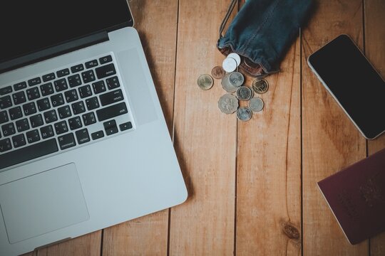 Directly Above Shot Of Laptop And Coins By Smart Phones On Table