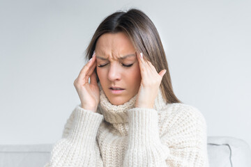 Young woman touching her temples because of strong tension headache. Cluster headache. Female suffering from migraine or stress. Hands on head. High quality photo