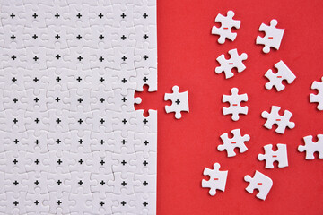 Positive and negative symbol on white puzzles with red background flat lay concept. This concept means we must join to positive environment to always keep positive in live.