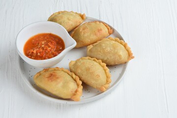 Pastel Goreng is Pastry Popular in Indonesia. fried pastry with filling of sautéed vegetable , chicken and boiled egg. accompanied with sauce or raw chilli pepper

