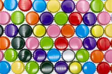 Background of colorful, lined crown corks or caps in different colors such as red, yellow, blue, orange and gold