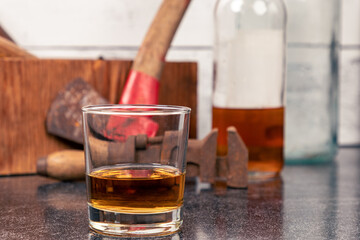 Glass of Bourbon Whiskey - Neat - in front of vintage tools