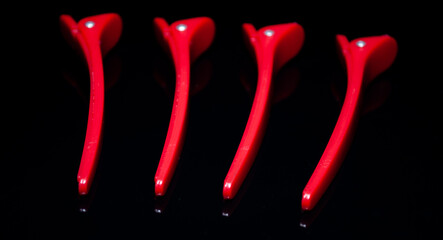 red hairdressing hairpins on a black background