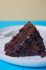 slice of home made moist chocolate cake with colourful background 