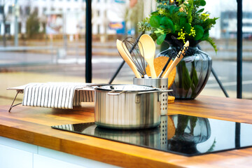 Worktop with hob and cooking equipment in front of a large window frontage