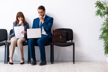 Young businessman and businesswoman waiting for an interview at