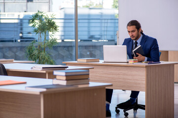 Young male teacher in suit in the classroom