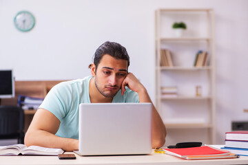 Young male student preparing for exams at home in tele-education