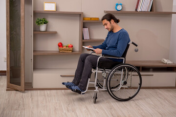 Young man in wheel-chair suffering at home