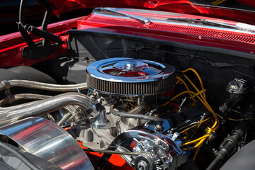 Fototapeta na wymiar An Under the Hood Side View of Restored Vintage Automobile Engine with Show-Chrome Air Filter