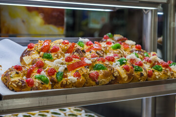 Lisbon, Portugal: Traditional Portuguese Christmas cake Bolo Rei with candied fruits and sugar toppings on bakery display.