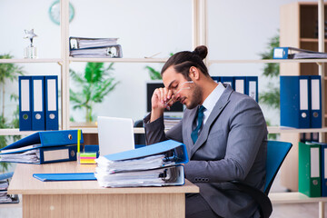 Young male employee and too much work in the office