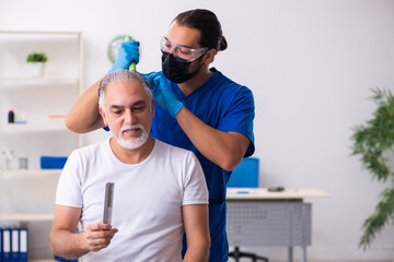 Old man visiting young male doctor in hair transplantation conce