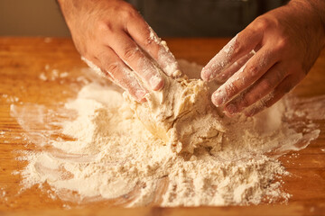Fototapeta premium cook kneads his preparation before baking