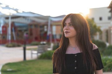 Preciosa joven en una bonita foto con el sol de espaldas y con un bonito brillo en el pelo moreno.