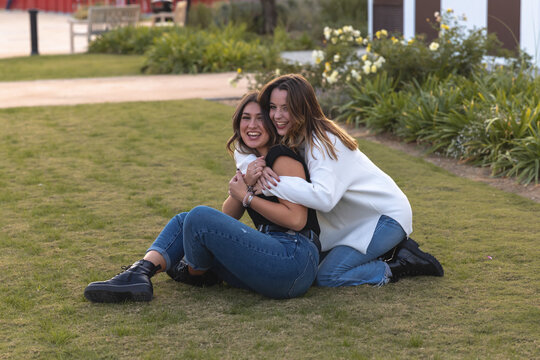 j&oacute;venes y guapas amigas abraz&aacute;ndose en naturaleza demostrando su amor o amistad entre risas.