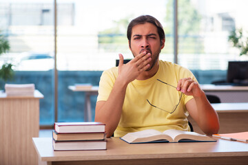 Young male student preparing for exams in the classroom