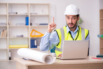 Young arm injured male architect working in the office