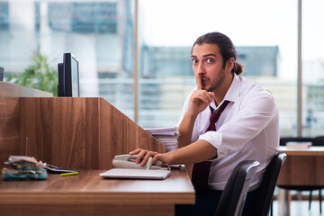 Young male employee in industrial espionage concept