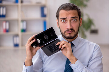 Young male employee wearing virtual glasses at workplace