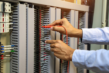 Close-up hand of electrical engineer using measuring equipment to checking electric current voltage...