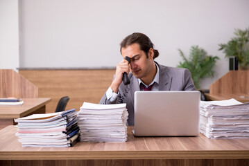 Young male employee unhappy with excessive work in the office