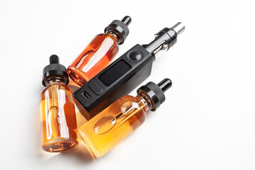 Electronic cigarette with a small display. Several bottles of vape juice next to e-cig. Concept of selling electronic devices for smoking. vape juice for refueling e-cigarettes. Vape juice for vaper