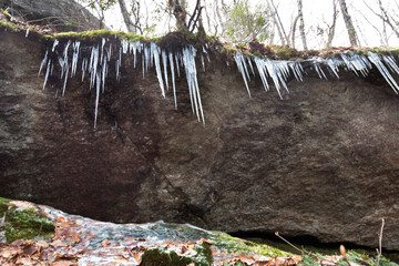 Icicles hanging from boulder in the woods in Barkhamsted, Connecticut.