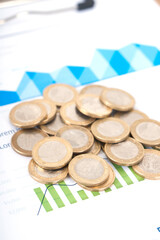 A pile of euro coins on financial documents