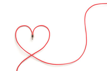 Red wire bent in the shape of heart on white background with copy space. A symbol of female sexuality. A symbol of love via the Internet.