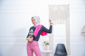 Young sporty muslim woman athlete in sportswear drinking water