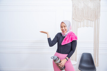 Fototapeta na wymiar Young sporty muslim woman athlete in sportswear drinking water