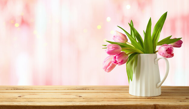 Beautiful tulip flower bouquet on wooden table over pink bokeh background. Valentine's day or mother's day concept