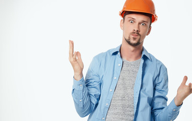 architect in orange helmet and unbuttoned shirt gesturing with hands cropped view white background