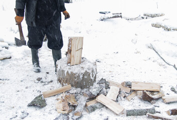 A MAN CHOPS WOOD IN WINTER 