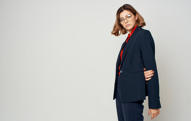 Business woman in a classic blue suit and a red shirt gestures Copy Space