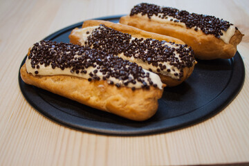 Traditional french eclairs with chocolate. Tasty dessert. Home made cake eclairs. Sweet Dessert Pastry filled with cream. Chocolate icing.
