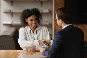 Thank you for good advice. Appreciative young african lady client shake hand of trusted male...