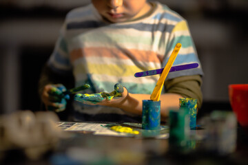 Young boy painting with colorful hands. Creativity and art , painting concept