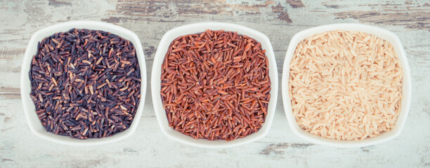 Vintage photo, Black, red and brown rice in glass bowls, healthy, gluten free nutrition concept