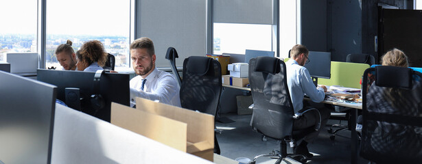 Group of young modern people in formalwear using modern technologies while working in the creative...