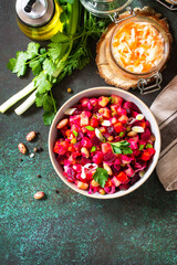 Beetroot salad vinaigrette with pickled cucumber, beans, carrots, peas, sauerkraut on a dark countertop. Top view flat lay. Copy space.