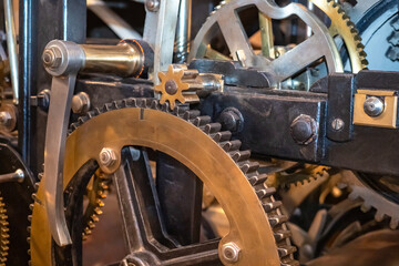 Background with many large gears. Textures on the theme of production and complex mechanisms. Industrial background. Copper gears close up. Large mechanism with gears. Manufacturing background
