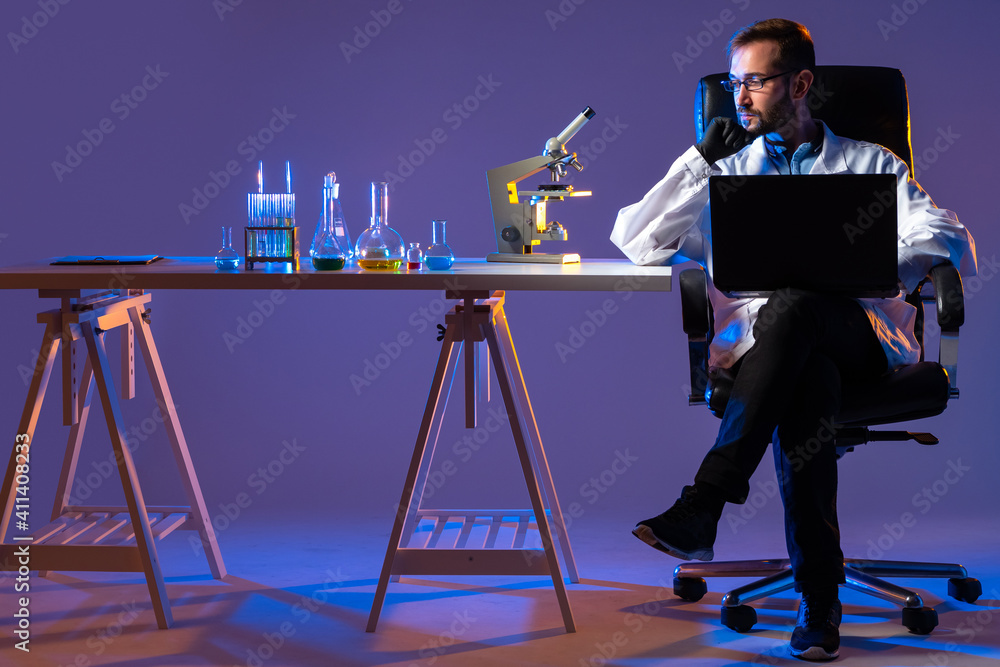 Poster man sits laboratory table. laboratory testing performed on component. laboratory testing components 
