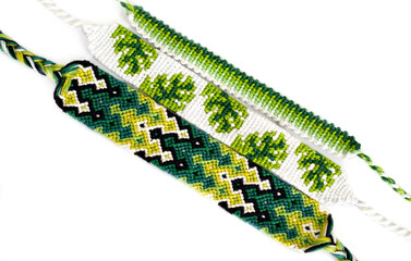 Woven DIY friendship bracelets handmade of embroidery floss with knots in green colors