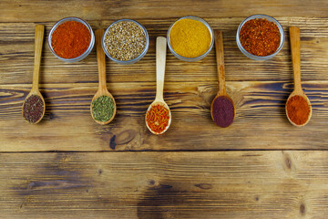 Set of different aromatic spices on wooden table. Top view