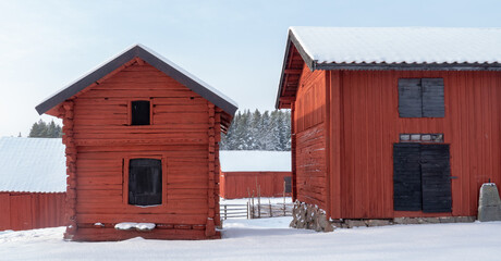 Farm barn and house in a cold winter landscape with snow and frost