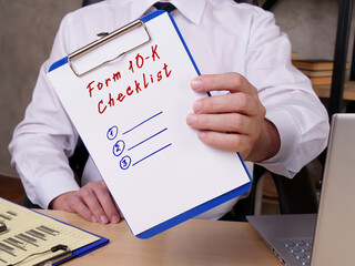  Financial concept meaning Form 10-K Checklist with sign on the sheet.