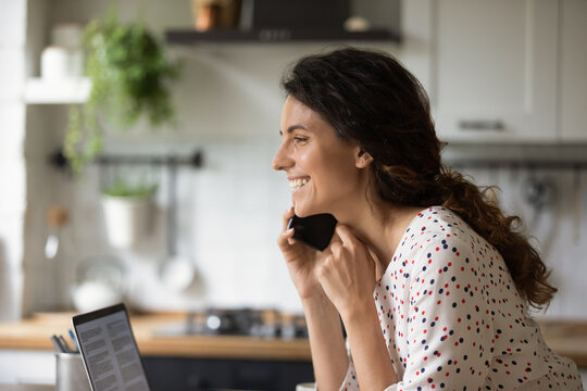 Close up of smiling millennial Caucasian woman have pleasant cellphone call at home office. Happy young female talk speak on smartphone, chat on gadget using mobile provider connection.